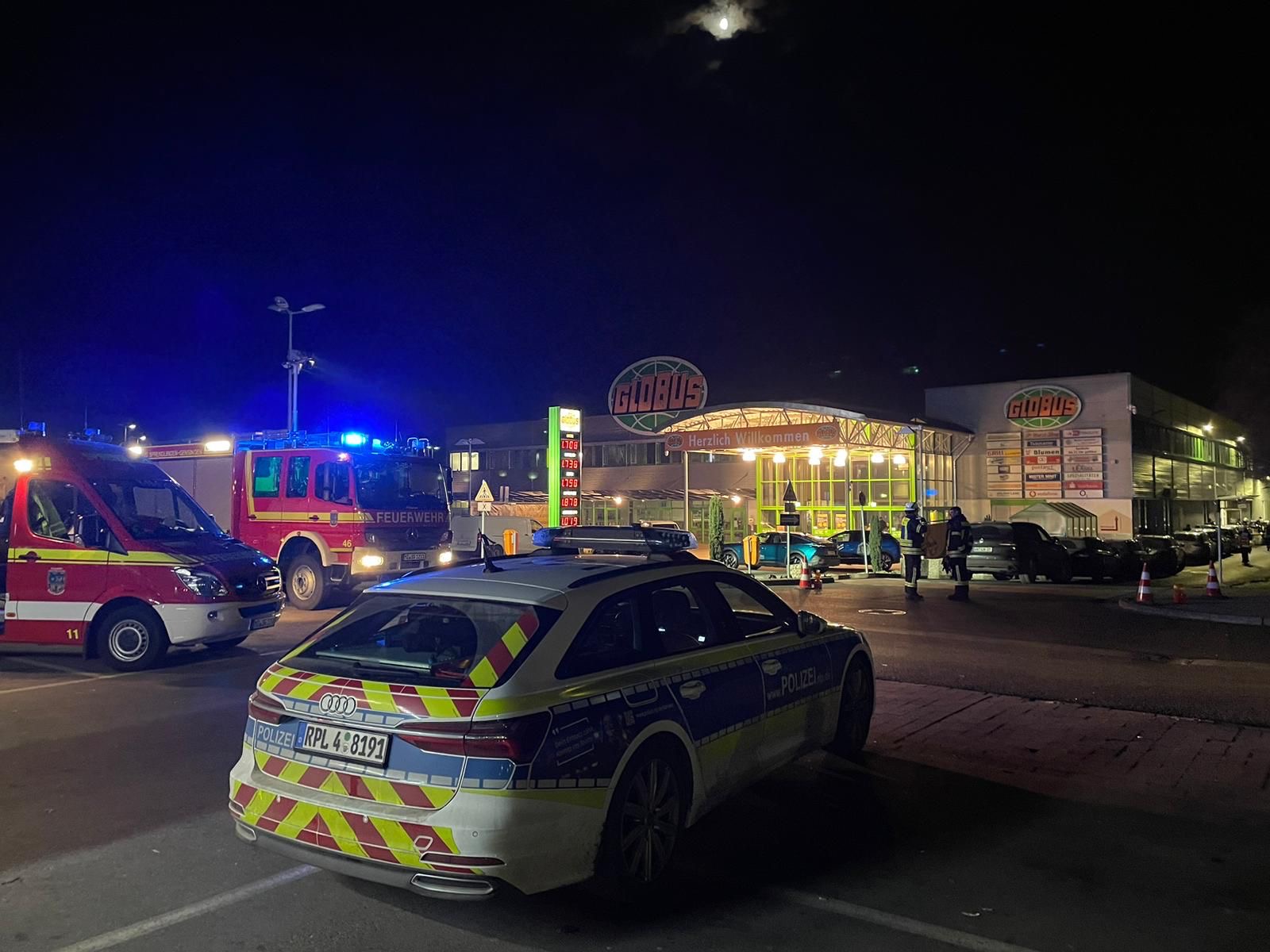 Das Foto zeigt ein Polizeiauto bei Nacht vor einem Supermarkt, in dem ein Geldautomat gesprengt wurde.